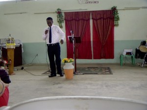 The pastor as he is delivering his sermon to us.